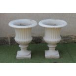 A PAIR OF VICTORIAN CAST IRON GARDEN URNS of half fluted campana form with ovolu moulded rim, fluted