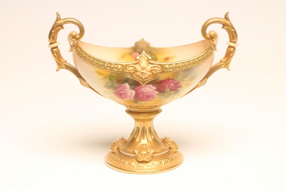 A ROYAL WORCESTER CHINA PEDESTAL BOWL, 1928, of boat form with two leaf sheathed scroll handles on a