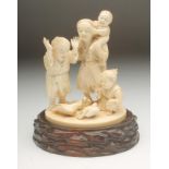 A JAPANESE SECTIONAL IVORY GROUP, Meiji period, carved as an old man carrying a child on his