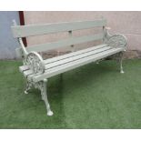 A CAST IRON GARDEN BENCH with slatted wood back and seat, the shaped sides moulded in a trailing