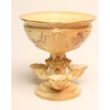 A ROYAL WORCESTER CHINA BLUSH IVORY CENTREPIECE, 1905, the strapwork moulded bowl raised upon a