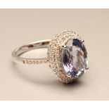 A TANZANITE AND DIAMOND RING, the oval cut tanzanite of approximately 3.50cts claw set within a