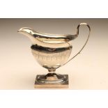 A GEORGE III SILVER MILK JUG, maker's mark W.F., London 1794, of oval form with applied reeded rim