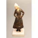 AN ART DECO BRONZE FIGURE, cast as a young Dutch girl, with her hands in her pockets, with carved