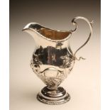 A LATE VICTORIAN SILVER MILK JUG, maker J B Carrington, London 1898, of semi wrythen fluted baluster