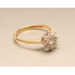 A NINE STONE DIAMOND CLUSTER RING, the round brilliants set to a plain 18ct gold shank, size M (Est.