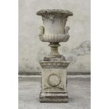 A LARGE COMPOSITION STONE URN of half fluted campana form with twin mask handles, with egg and