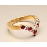 A RUBY AND DIAMOND WISHBONE RING, the five rubies and four round brilliant cut diamonds set to a