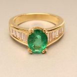 AN EMERALD AND DIAMOND DRESS RING, the oval facet cut emerald claw set to wide tapered shoulders