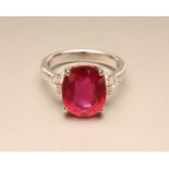 A RUBY RING, the oval facet cut stone of approximately 6cts, claw set to shoulders each with three