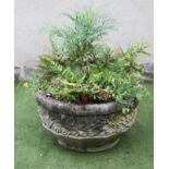 A COMPOSITION STONE PLANTER of faceted circular form, moulded with a band of trailing foliage over a