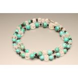 A SINGLE STRING OF TURQUOISE BEADS, the graduated beads interspersed with square facet cut clear