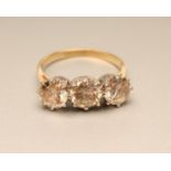 A THREE STONE DIAMOND RING, each old brilliant cut stone of approximately 1ct, claw set to a plain