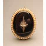 A VICTORIAN MOURNING BROOCH, the slightly convex polished oval onyx panel centred by an old cut