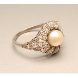AN ART DECO PEARL AND DIAMOND COCKTAIL RING, the open panelled border and shoulders set with