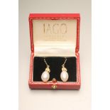 A PAIR OF PEARL DROP EARRINGS, the tear drop shaped pearls drilled and set to triple leaf gold