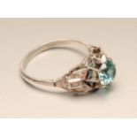 A BLUE ZIRCON AND DIAMOND DRESS RING, the circular facet cut zircon claw set to brilliant and