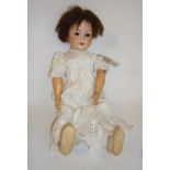 An Armand Marseille bisque head doll with brown glass sleeping eyes, open mouth and teeth, brown