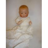 An Armand Marseille bisque head baby doll with blue glass sleeping eyes, open mouth, moulded hair,