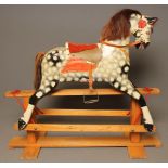 A rocking horse, possibly Lines Bros, mid 20th century, in dappled painted carved wood, with
