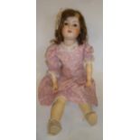 An Armand Marseille bisque head doll with brown glass sleeping eyes, open mouth and teeth, brown