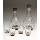 AN ORREFORS GLASS PART SUITE, designed by Simon Gate, comprising two graduated decanters with