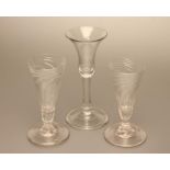 A PAIR OF GEORGIAN GLASS ALE FLUTES, c.1800, the wrythen moulded conical bowl on short panelled stem