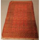 A WEST PERSIAN RUG, the madder red field with all over repeating grid pattern, in ivory, brown and