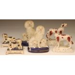 A PAIR OF VICTORIAN STAFFORDSHIRE POTTERY SPANIEL INKWELLS, the recumbent black and white dogs