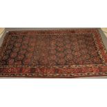 A PERSIAN TRIBAL RUG, the navy blue field with repeating large floral boteh in pale blue, ivory