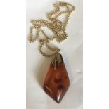A 9ct gold mounted amber drop pendant on 9ct gold chain.