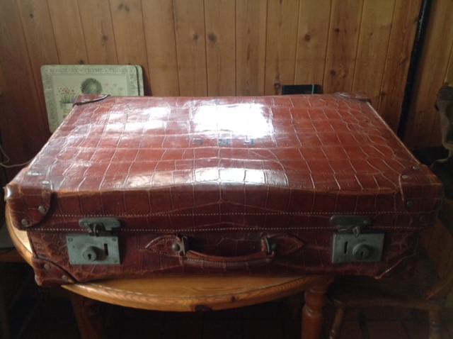 Good quality crocodile skin suitcase fitted with silver mounted toiletry bottles etc.