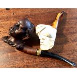 Two carved head pipes, chip to one