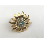 Yellow metal diamond and emerald brooch in the form of a flower 3cms d