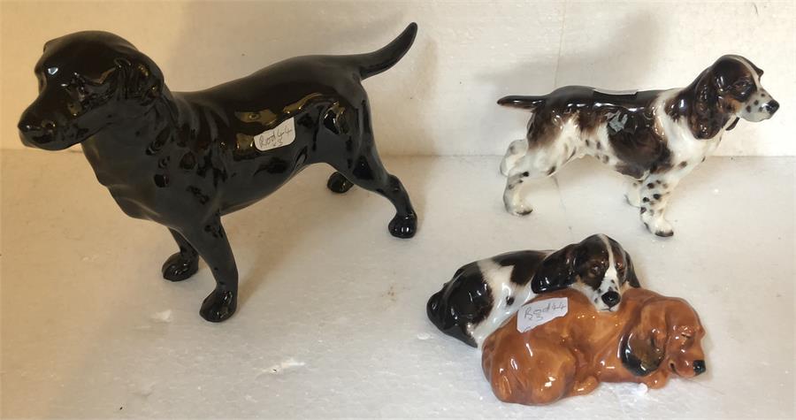 Three Royal Doulton figures of dogs.