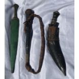 A plaited leather whip, A Gurkha knife in scabbard and a brass handled dagger in wood and green skin