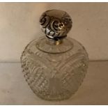 A cut glass scent bottle, hinged silver lid with repoussé work decoration and vacant cartouche