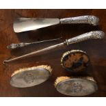 Two brushes, shoe horn and two button hooks all with silver mounts and another brush