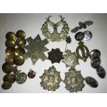 A quantity of cap badges and uniform buttons.