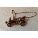 Yellow metal gem set and enamel brooch in the form of a vintage car .Slight a/f to enamel. Marked to