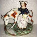 A 19thC Staffordshire cow and milkmaid. 15cms h. Slight chip to hat.