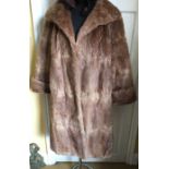 Musquash fur coat together with faux fur hat.