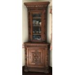 Continental double height carved oak corner cupboard - glazing to top of door.