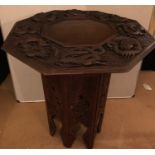 Oriental carved hardwood folding table with dragons carved to top.