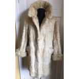 A vintage cream coloured fur jacket.