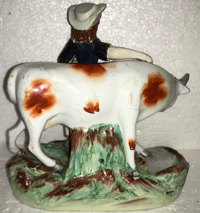 A 19thC Staffordshire cow and milkmaid. 15cms h. Slight chip to hat. - Image 2 of 2