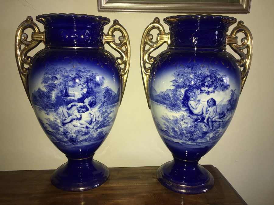 A pair of 19thC blue and white vases depicting cherubs, slight repair to one top. - 39cms h