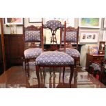 A SET OF 8 DINING ROOM CHAIRS, with carved and padded back supports, raised on turned and castored