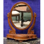 A MAHOGANY SWING MIRROR/DRESSING MIRROR, with carved foliage supports, on a shaped platform base