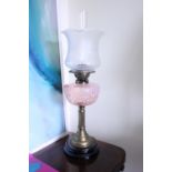 A FINE VICTORIAN OIL LAMP, with cranberry opaque glass reservoir, frosted glass shade and clear
